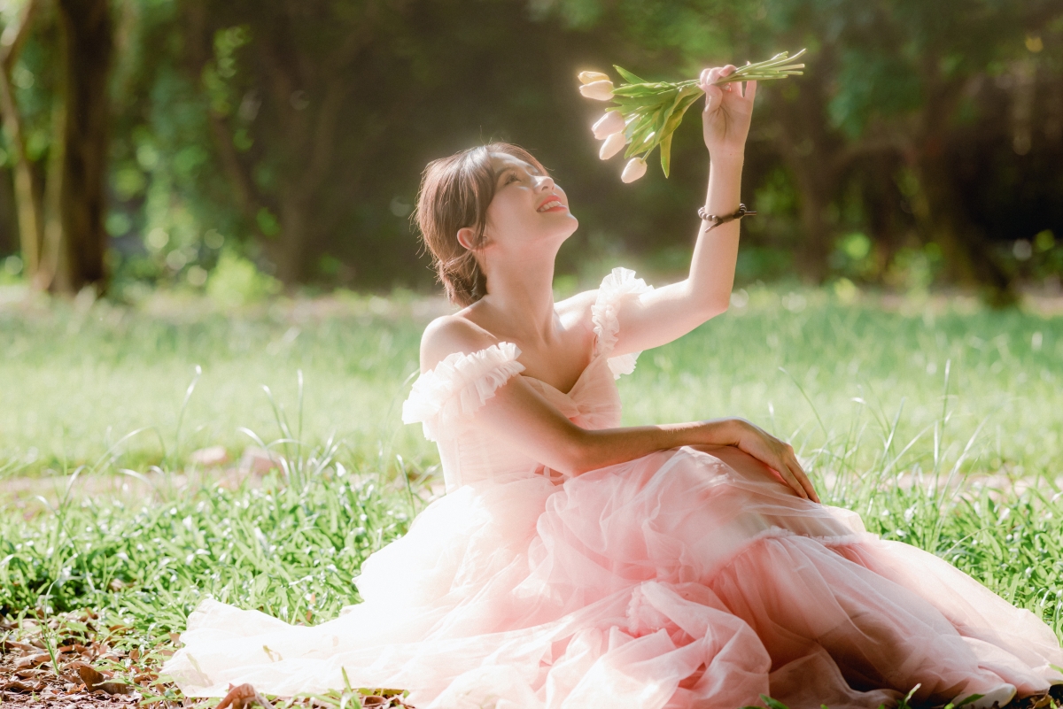 女神节快乐 森林 坐在草地上的美女 手拿着鲜花 微笑 4k壁纸